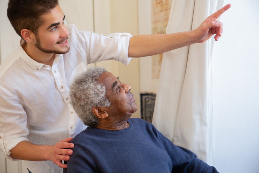 A carer assists an older man at home